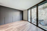 Modern apartment boasting sleek dark gray built-in wardrobes and stunning floor-to-ceiling windows offering breathtaking views.