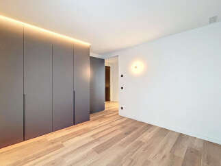 Modern apartment boasts sleek built-in wardrobes and light oak wood flooring.
