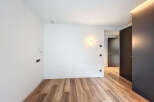 This stunning property boasts a spacious, bright bedroom with sleek hardwood floors and modern wall sconces.
