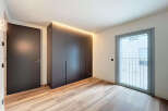 Modern apartment boasting sleek built-in wardrobes and light oak flooring.
