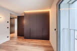 Modern apartment boasts sleek built-in wardrobes with integrated lighting, enhancing the minimalist aesthetic.