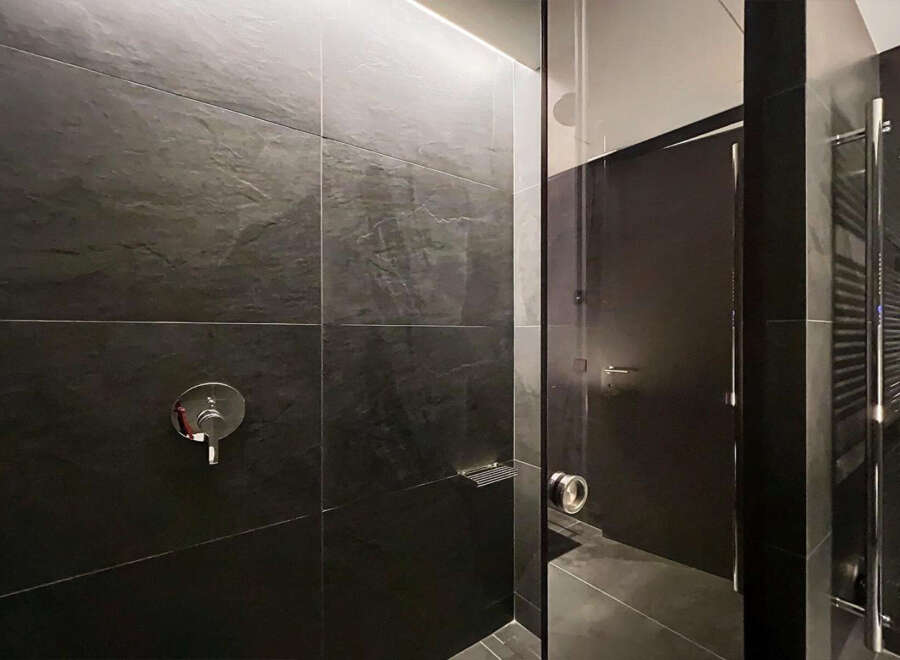 Modern bathroom with dark slate tiles and sleek fixtures.