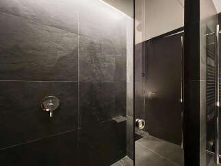 Modern bathroom with dark slate tiles and sleek fixtures.