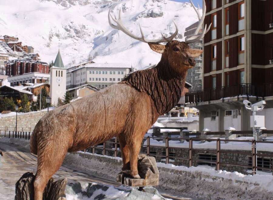 Discover the charm of this property, featuring a stunning wooden elk sculpture as a focal point.