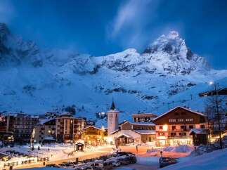 Experience the magic of a snow-covered village nestled at the foot of majestic mountains.