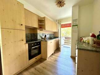 This charming kitchen boasts beautiful wooden cabinetry and a sleek granite countertop, creating a warm and inviting atmosphere.