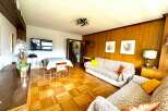 Discover a cozy living space with beautiful parquet flooring and warm wooden paneling.