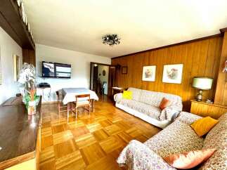 Discover a cozy living space with beautiful parquet flooring and warm wooden paneling.