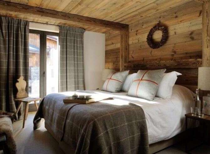 This cozy bedroom features rustic wooden walls and ceiling, creating a warm and inviting atmosphere.