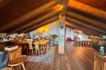 Step into a rustic haven with this stunning property, featuring a spacious interior with exposed wooden beams and a warm, inviting atmosphere.