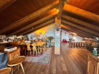 Step into a rustic haven with this stunning property, featuring a spacious interior with exposed wooden beams and a warm, inviting atmosphere.