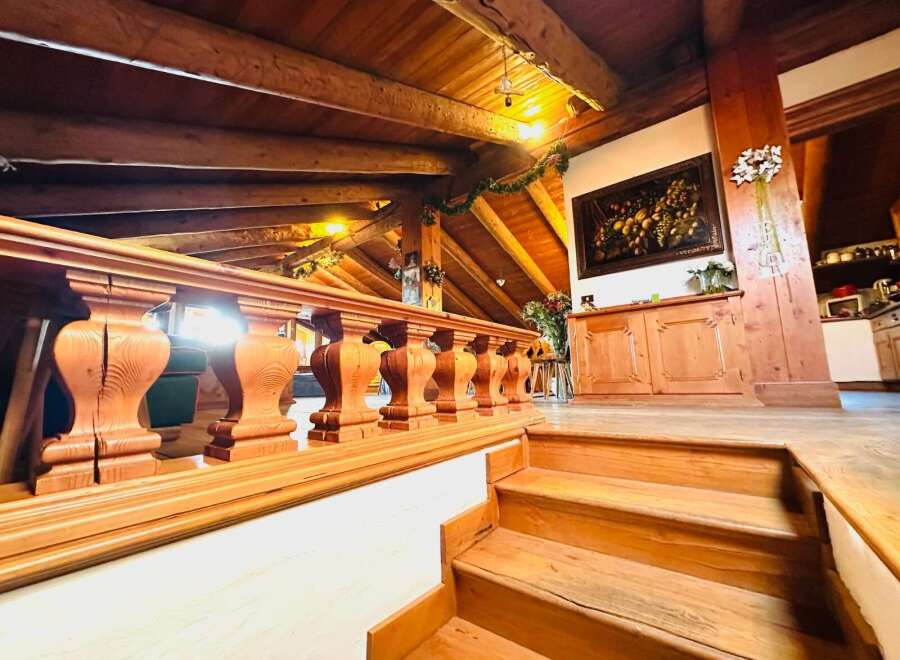 Step into a world of rustic elegance with this stunning property, featuring a beautifully crafted wooden staircase and a charming balustrade.