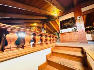 Step into a world of rustic elegance with this stunning property, featuring a beautifully crafted wooden staircase and a charming balustrade.