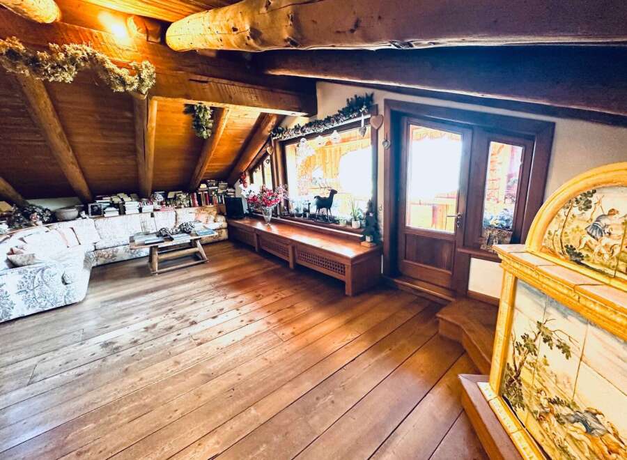 Step into a cozy and inviting living space with stunning wooden floors and a unique architectural design.
