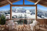 Cozy chalet balcony with stunning snowy mountain views.