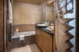 This luxurious bathroom boasts a spacious bathtub, a sleek vanity with ample storage, and a walk-in shower, perfect for relaxation after a day on the slopes.