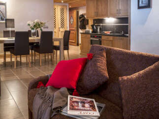 This stunning apartment boasts an open-plan living area with a comfortable sofa and a dining area perfect for family meals.