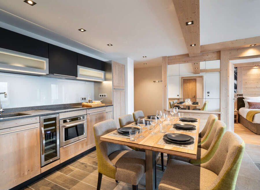 This stunning apartment boasts a modern, open-plan kitchen with high-end appliances and ample counter space, seamlessly flowing into a spacious dining area perfect for entertaining.