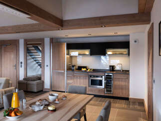 This stunning apartment boasts a spacious open-plan living area with a modern kitchen featuring sleek cabinetry and high-end appliances.