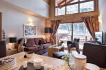 This stunning chalet boasts a spacious open-plan living area with floor-to-ceiling windows offering breathtaking mountain views.