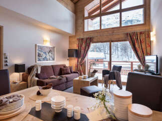 This stunning chalet boasts a spacious open-plan living area with floor-to-ceiling windows offering breathtaking mountain views.