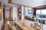 This stunning apartment boasts a spacious open-plan living area with a modern kitchen, dining table, and comfortable seating, perfect for relaxing after a day on the slopes.