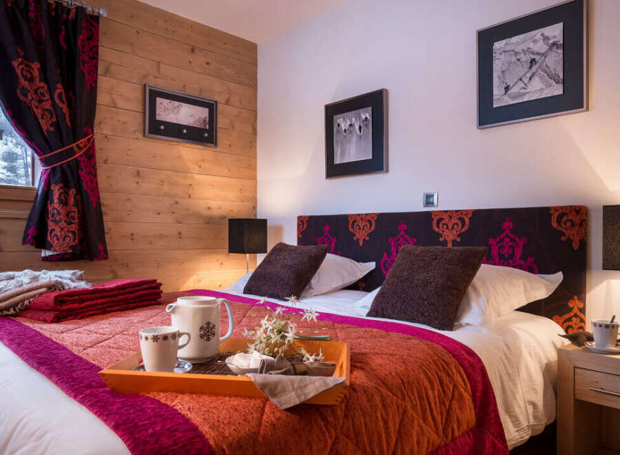 Cozy bedroom with a king-size bed, featuring a rich color palette and patterned headboard.