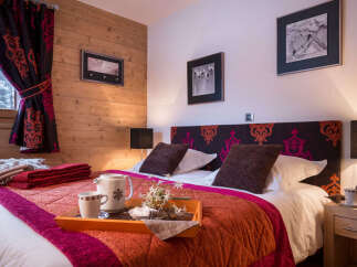 Cozy bedroom with a king-size bed, featuring a rich color palette and patterned headboard.