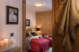 Cozy chalet bedroom with twin beds, wooden walls, and a warm atmosphere.