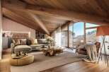 Luxurious chalet apartment boasting a stunning wooden beamed ceiling and expansive windows offering breathtaking mountain views.