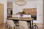 Stylish apartment featuring an open-plan kitchen and dining area with wooden accents.