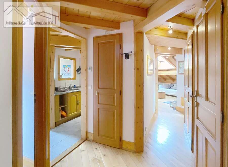 Discover the charm of this inviting property, featuring a warm wooden interior and a well-lit hallway.