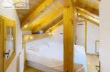 Discover a cozy bedroom with a unique wooden ceiling and beams, creating a warm and inviting atmosphere.