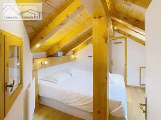 Discover a cozy bedroom with a unique wooden ceiling and beams, creating a warm and inviting atmosphere.