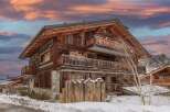 This stunning chalet boasts a rustic-chic design with exposed wooden beams and stone accents.