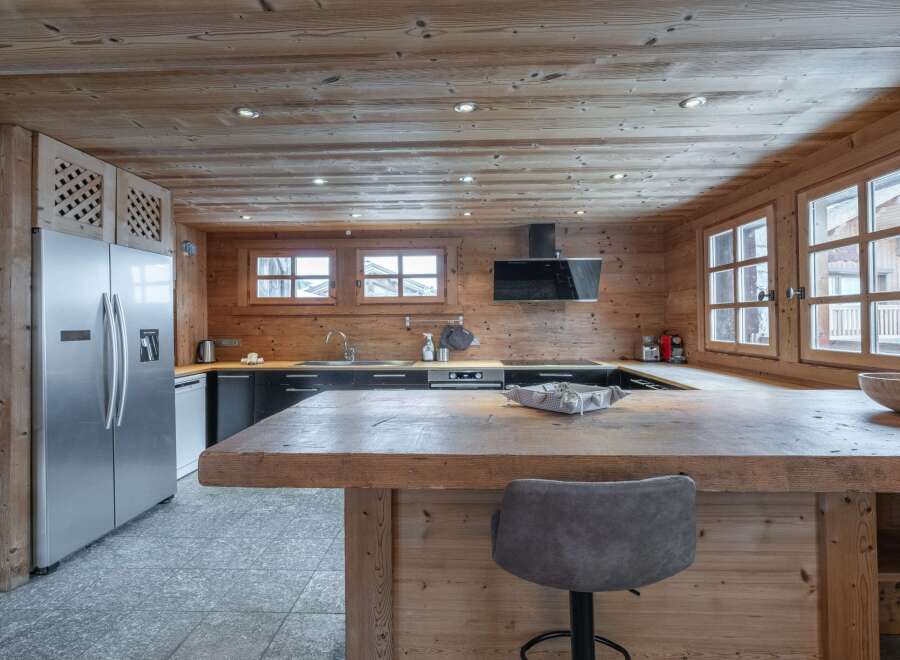 This stunning chalet boasts a spacious kitchen with rustic wooden features and modern appliances.