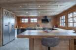 This stunning chalet boasts a spacious kitchen with rustic wooden features and modern appliances.
