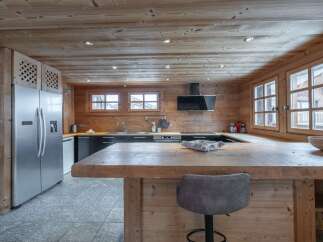 This stunning chalet boasts a spacious kitchen with rustic wooden features and modern appliances.