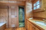 Rustic wooden bathroom with a walk-in shower, wooden vanity with sink, and a bathtub.