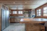 This stunning chalet boasts a rustic-chic kitchen with exposed wooden beams, granite countertops, and top-of-the-line stainless steel appliances.