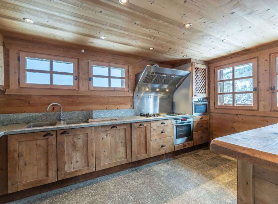 This stunning kitchen boasts a rustic-chic design with exposed wooden beams and a granite countertop.