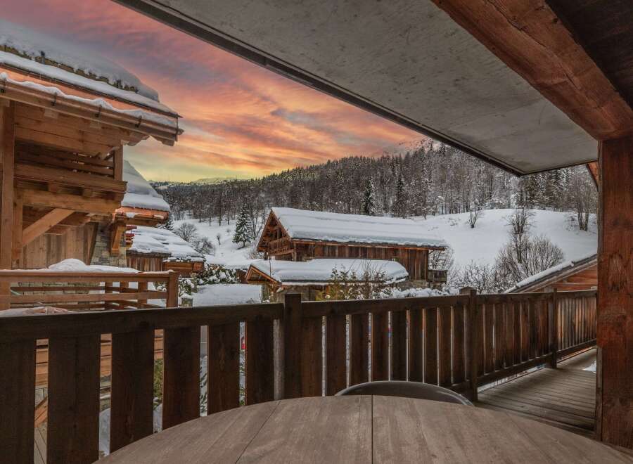 This stunning chalet boasts breathtaking views of a snow-covered landscape, perfect for a cozy winter getaway.