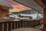 This stunning chalet boasts breathtaking views of a snow-covered landscape, perfect for a cozy winter getaway.