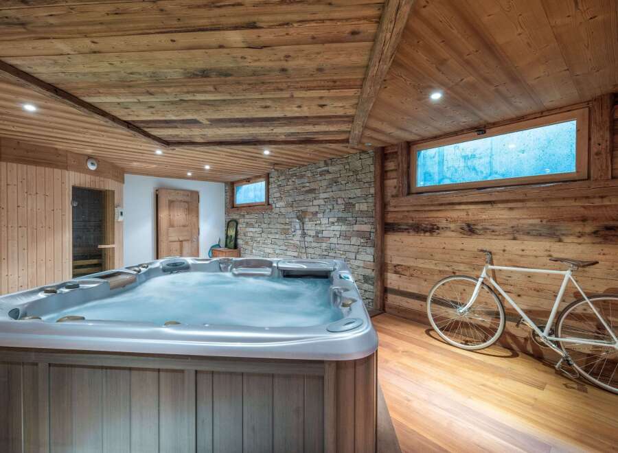 Luxury chalet with stunning wooden interior, featuring a spacious hot tub and private sauna for ultimate relaxation.