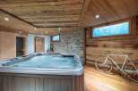Luxury chalet with stunning wooden interior, featuring a spacious hot tub and private sauna for ultimate relaxation.