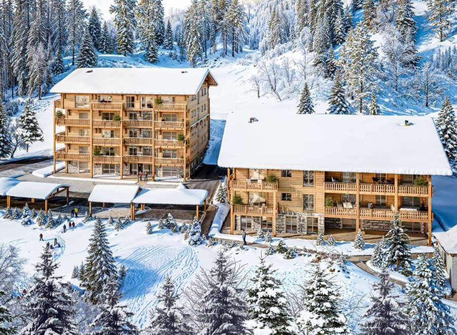 Discover luxurious chalet-style apartments nestled in a breathtaking snowy mountain setting.