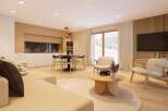 This stunning apartment boasts an open-plan living area with a cozy sofa and armchairs, perfect for relaxing after a day on the slopes.