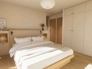 This stunning bedroom boasts a minimalist design with built-in wardrobes and a light oak wood platform bed.