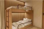 Cozy bunk bed in a modern room with wooden walls and neutral tones.