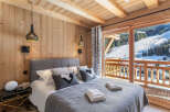 Wake up to breathtaking mountain views from this luxurious chalet bedroom.